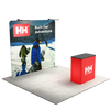 Three quarter booth view featuring a straight tension fabric backdrop with mounted LED lights and branded counter.