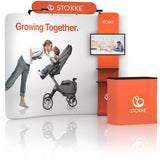 10ft QuickZip Max Curved trade show display with printed fabric backdrop, shelving tower, and counter.